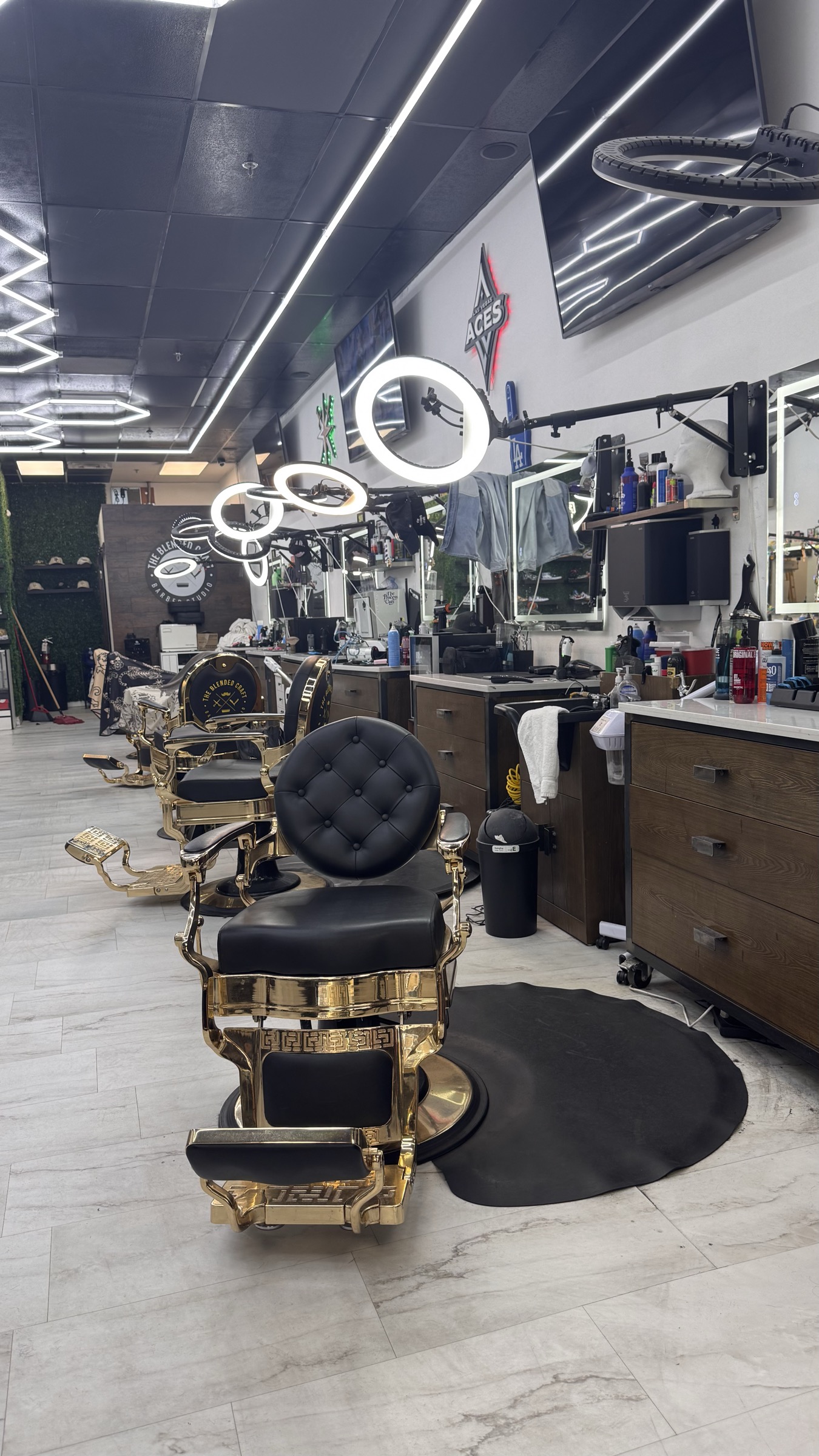 Gold and black barber chair with ring lights at Blended Craft